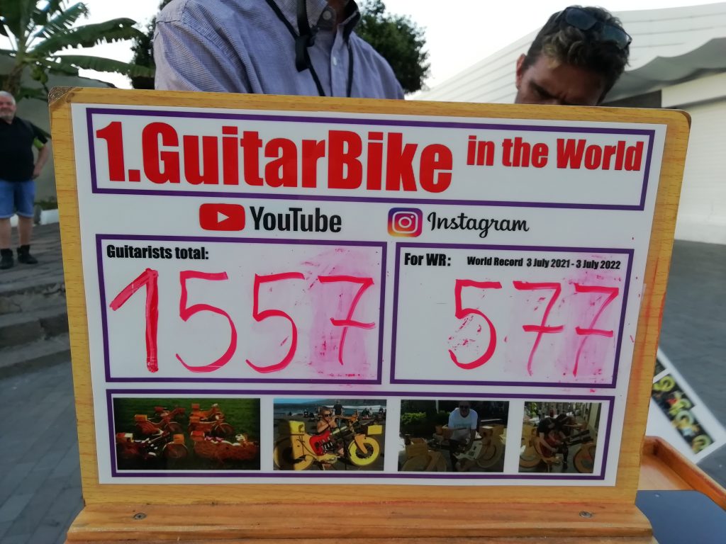 cedulka s nápisem "Guitar bike in the world" s počtem kytaristů, kteří si na něj už zahráli - současně je to 1557.