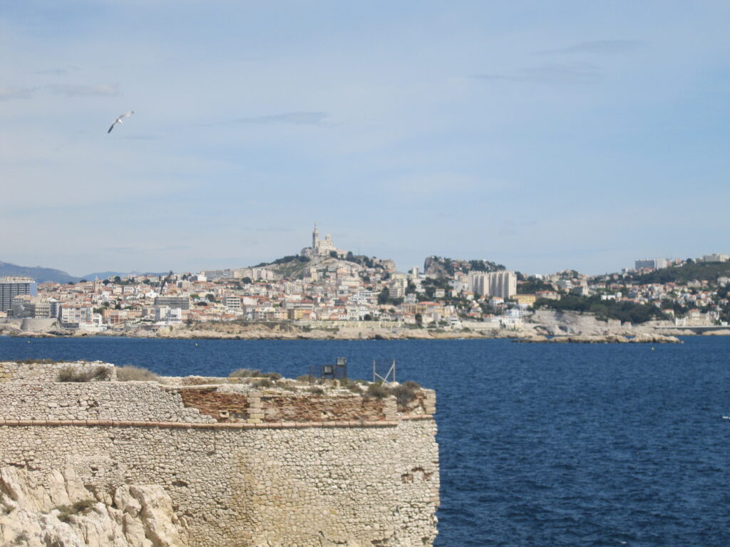 Vyhlídka od Chateau d'If na Marseille s katedrálou Notre Dame de la Garde na kopci